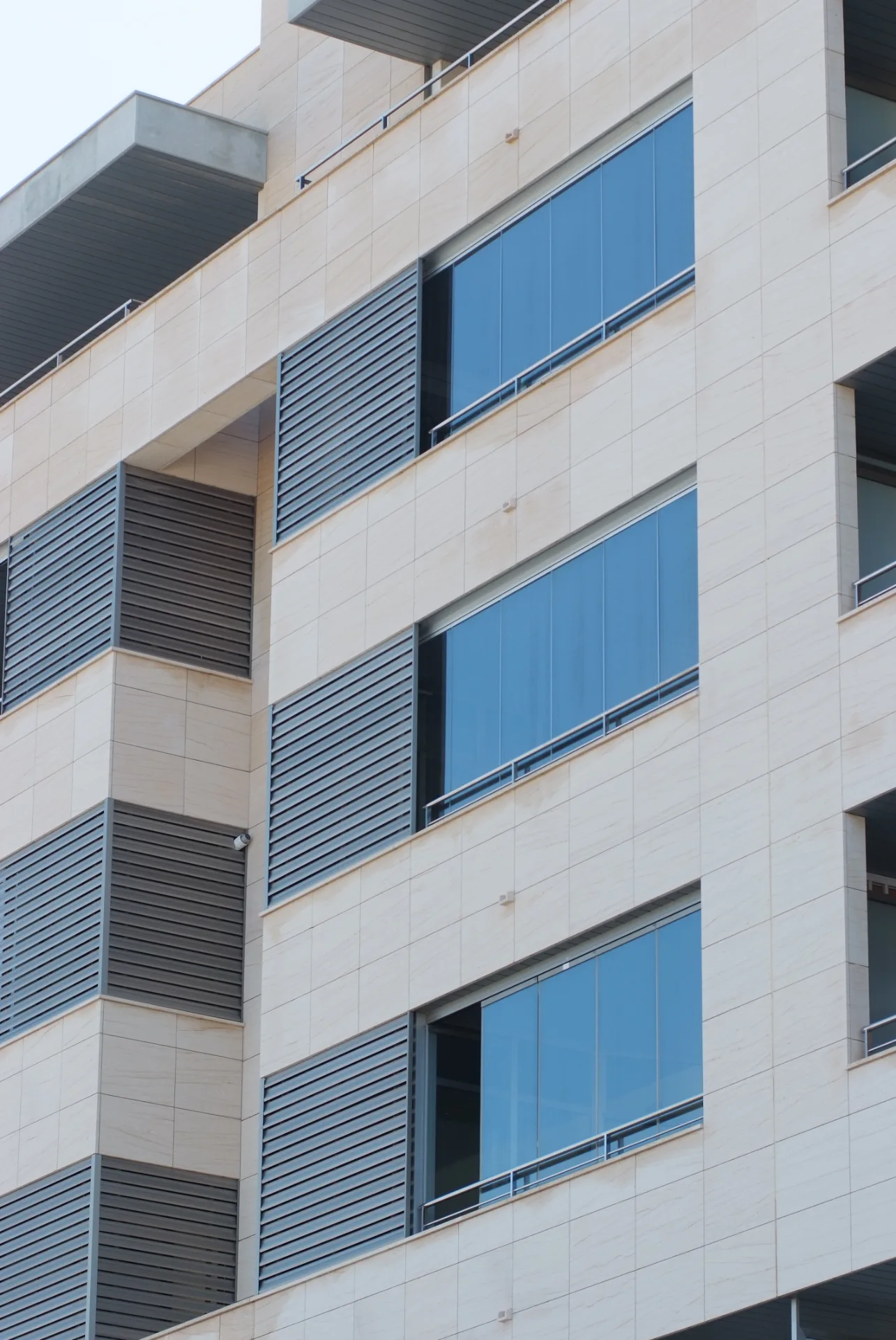 Fachada vertical con varios balcones cerrados en cristal