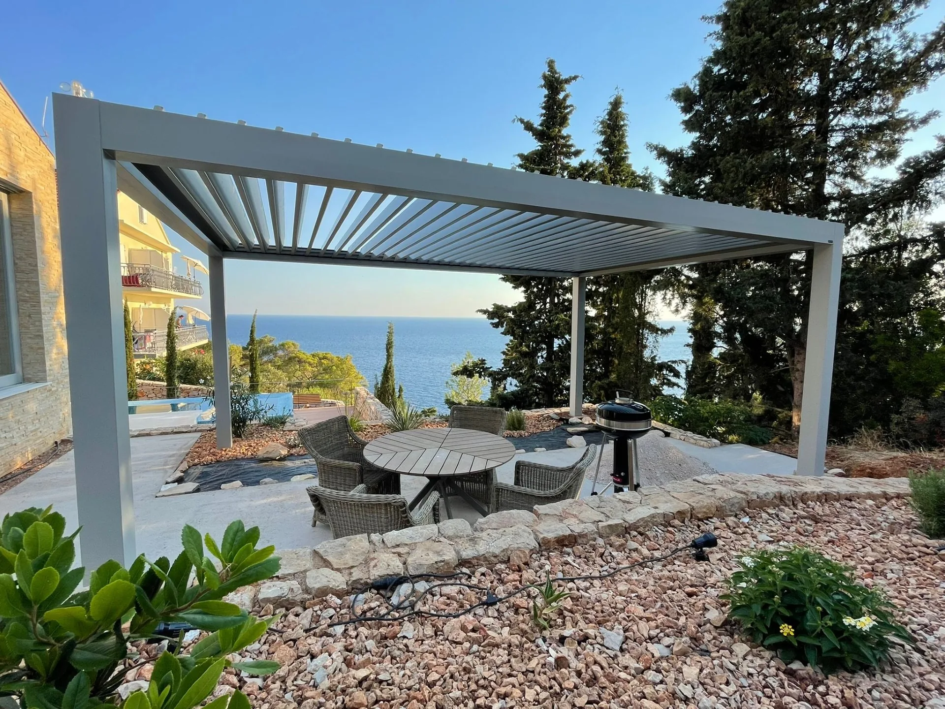 Pérgola bioclimática en un jardín con vistas a la montaña