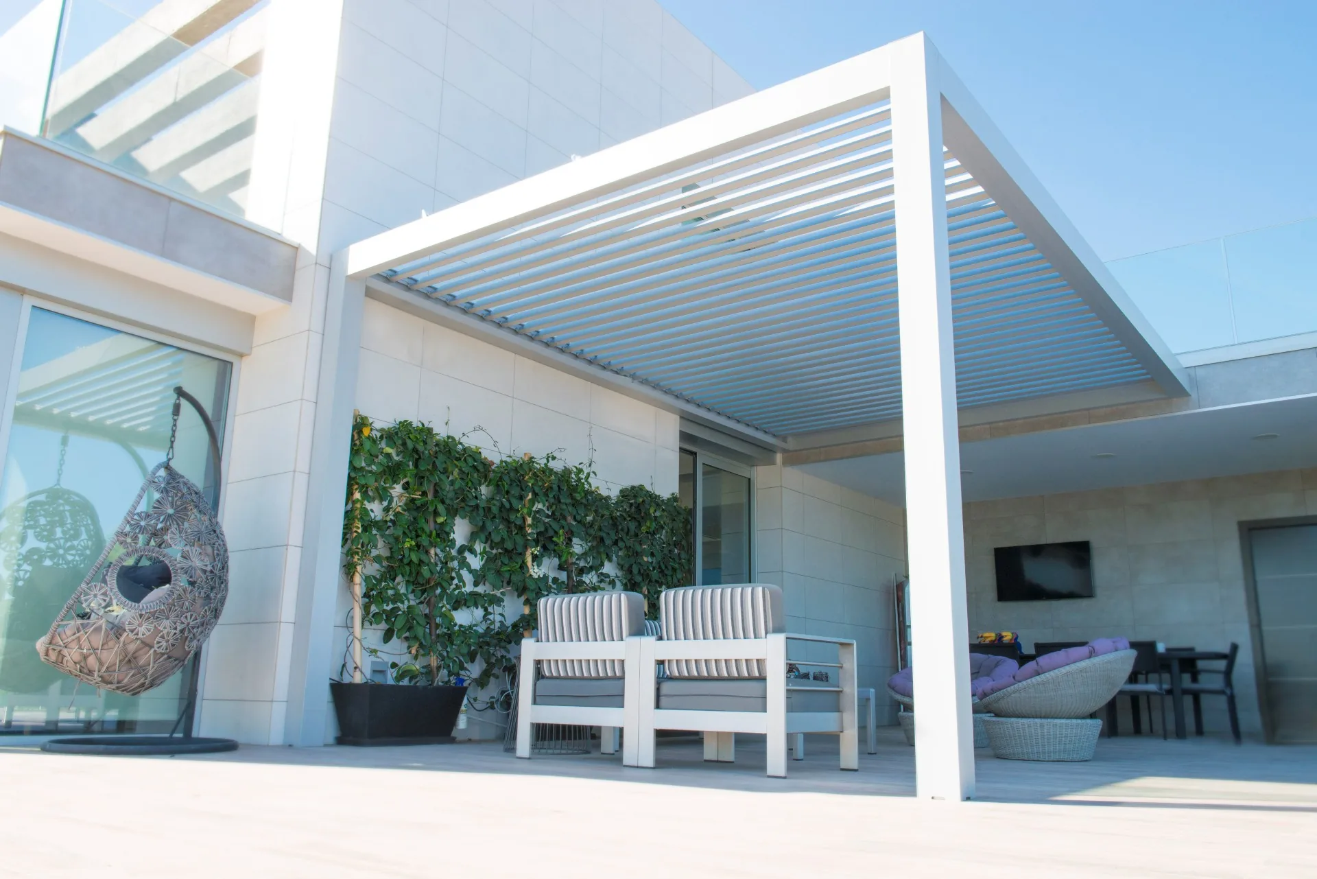 Pérgola blanca adosada al patio de una vivienda contemporánea
