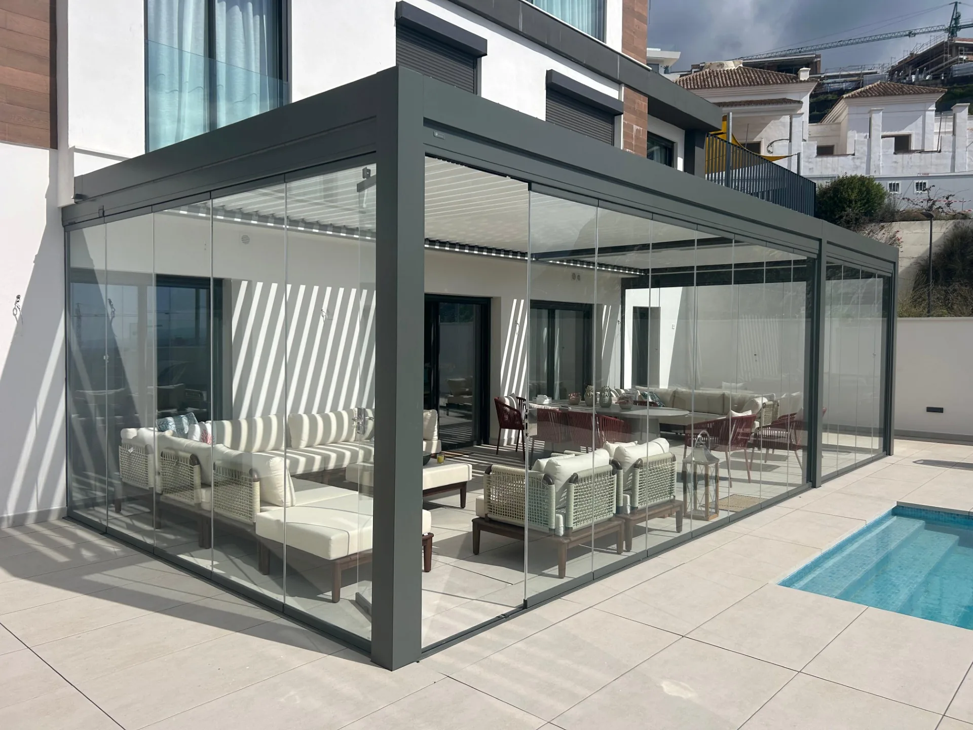 Pérgola acristalada junto a una piscina residencial