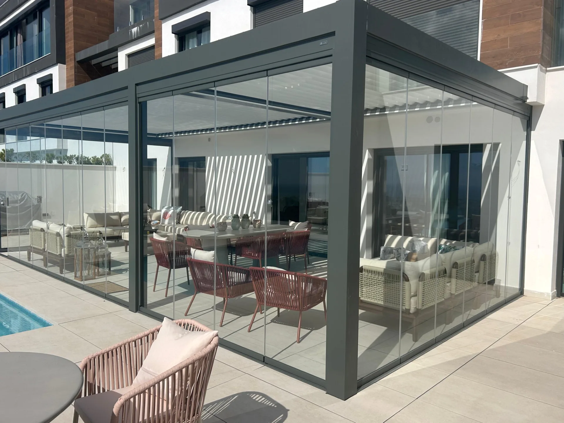 Cerramiento de cristal integrado en una pérgola gris