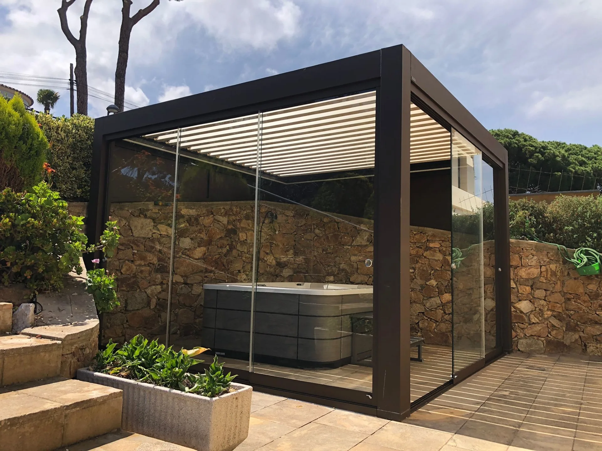 Zona de bienestar exterior rodeada por un cerramiento de cristal